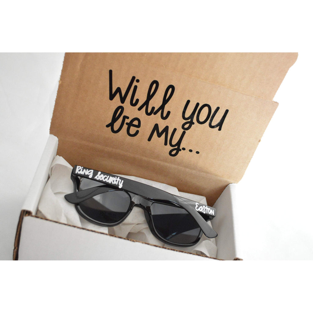 will you be my ring security proposal box with youth black sunglasses and white text